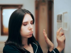 Woman Feeling Hot Setting The Room Temperature To Be Lower (1)